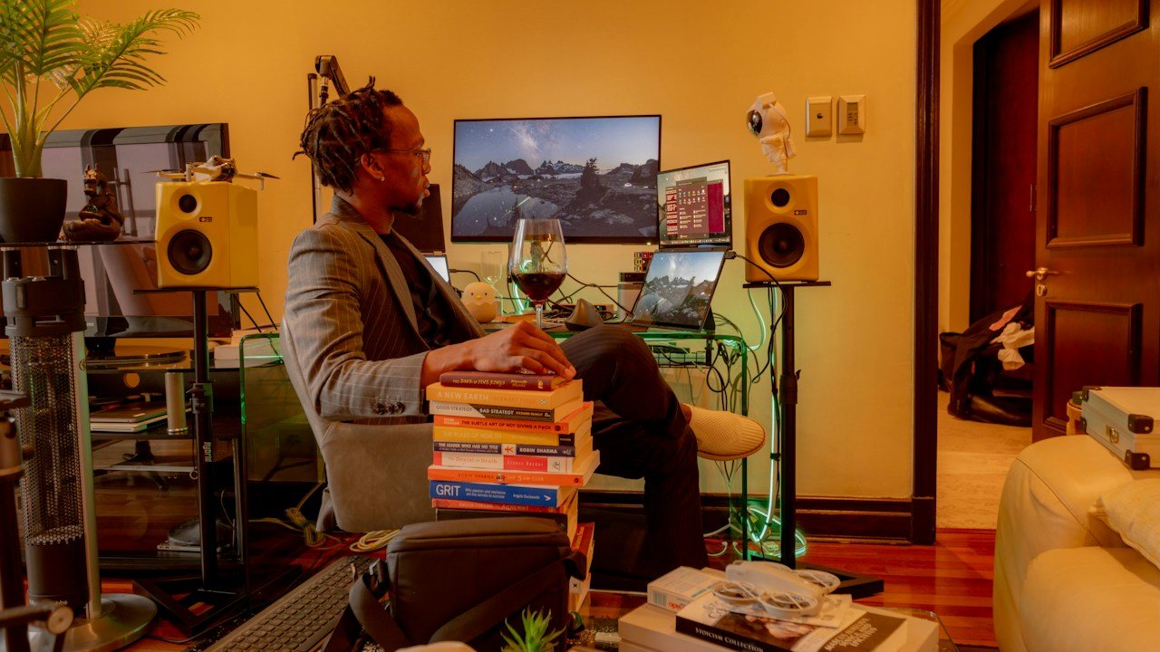 Man relaxing in a home office with monitors and speakers