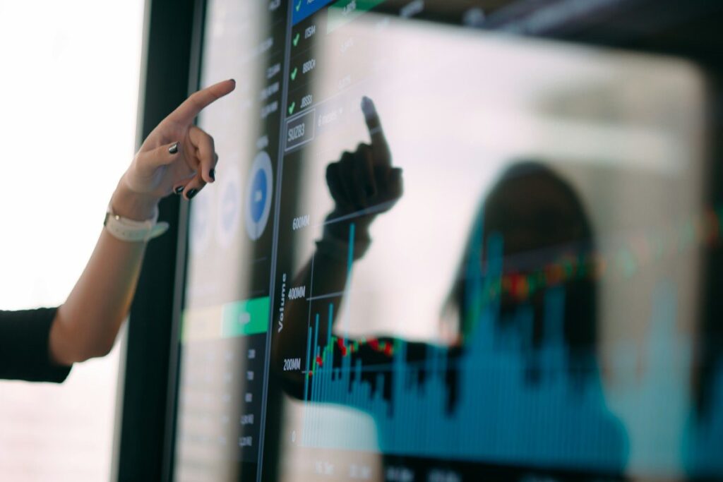 Trader pointing at a chart to judge whether price sits at a level or mid-range before a trade