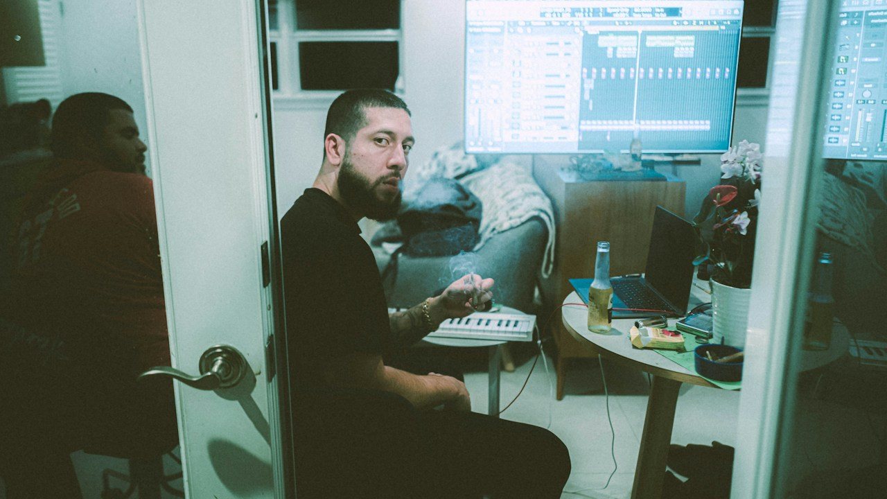 Man at a desk with monitors in a small office