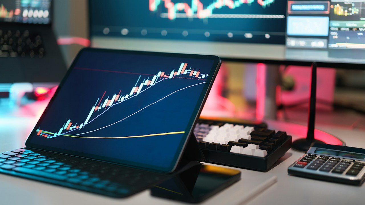 Trader watching a price chart with a momentum indicator panel below it, the set-up used for RSI divergence trading