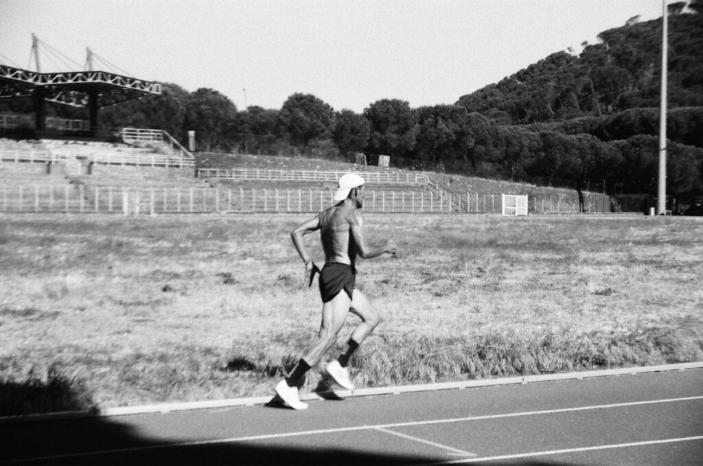 Runner on an athletics track in black and white, like a trader pacing their recovery after a drawdown