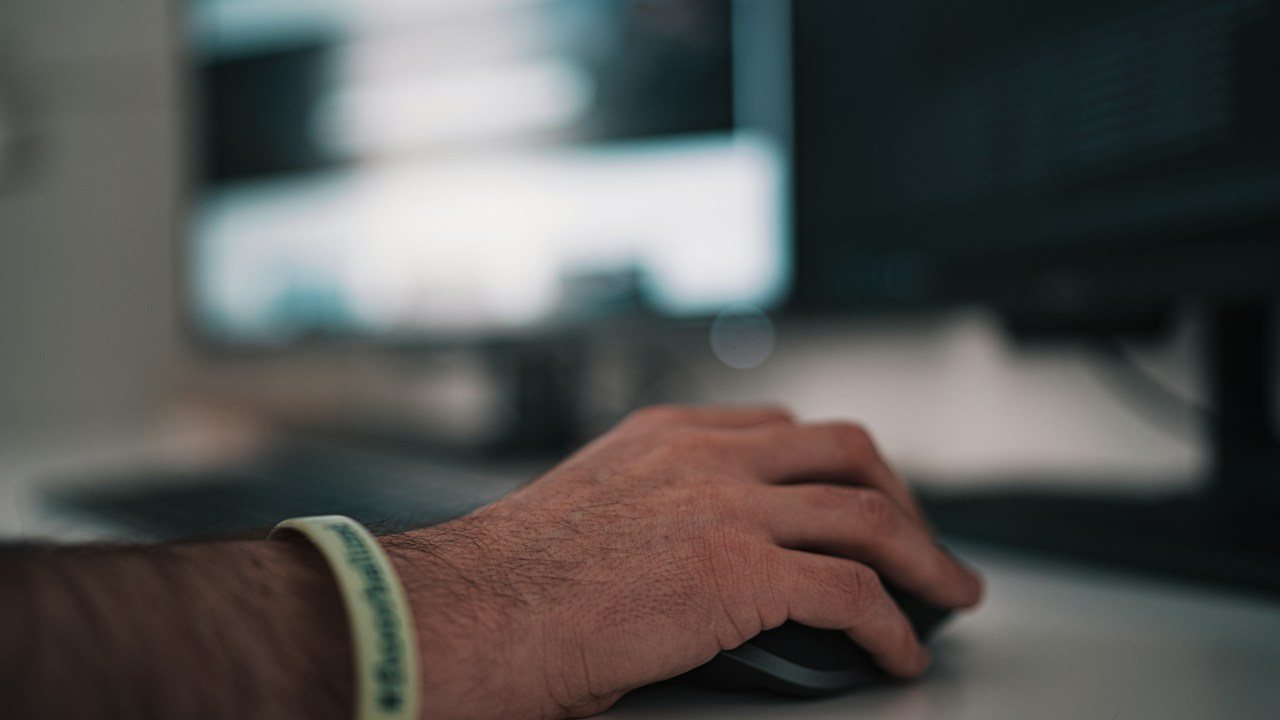 Hand on a computer mouse at a desk
