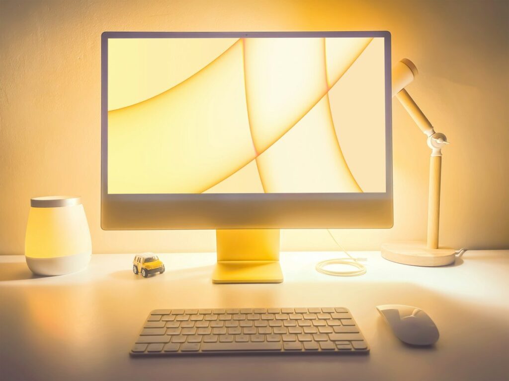 Desktop monitor on a desk, where a trader records the stop level beyond a pin bar wick