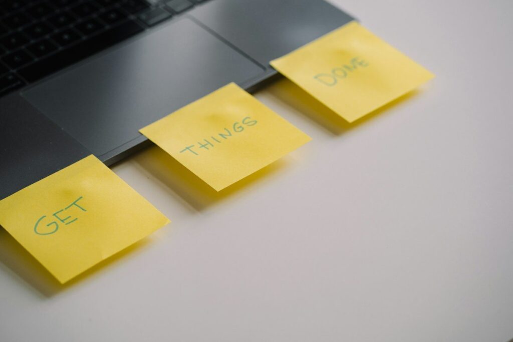 Yellow sticky notes on a laptop keyboard, used to jot down the high and low of a trading range