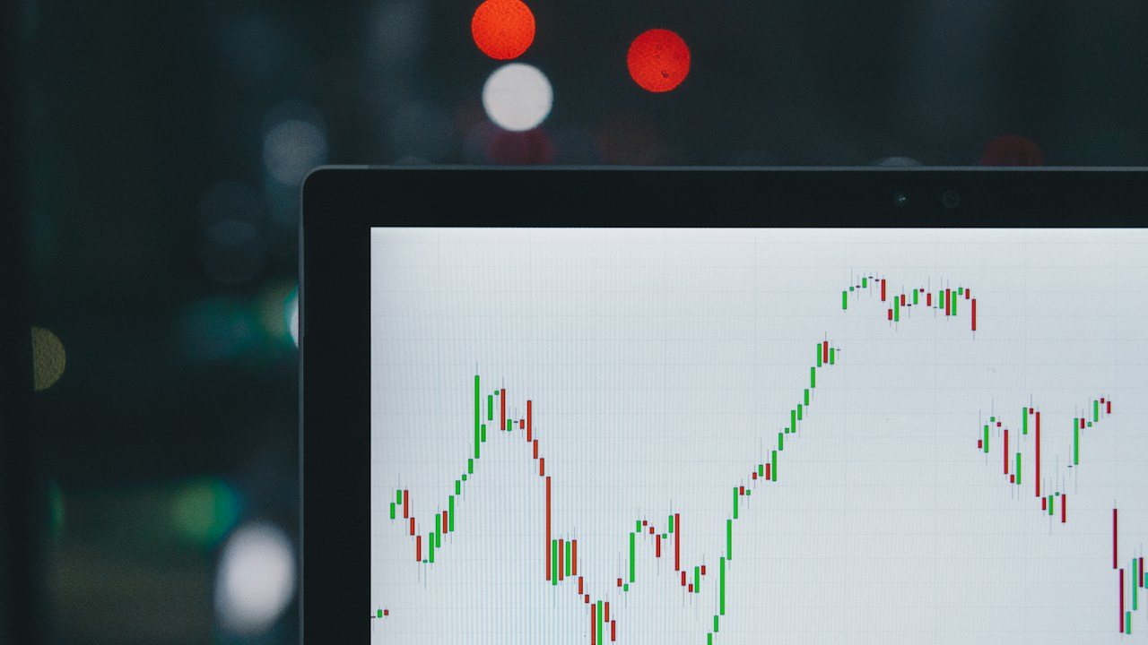Laptop screen showing a candlestick chart