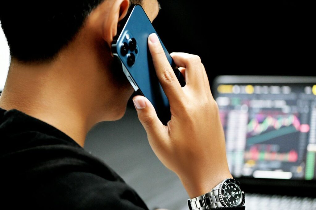 Man on a phone call in front of a chart screen