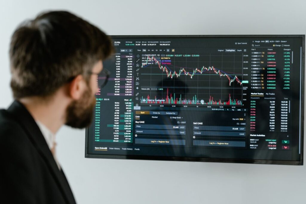 Man in glasses looking at a wall screen of charts