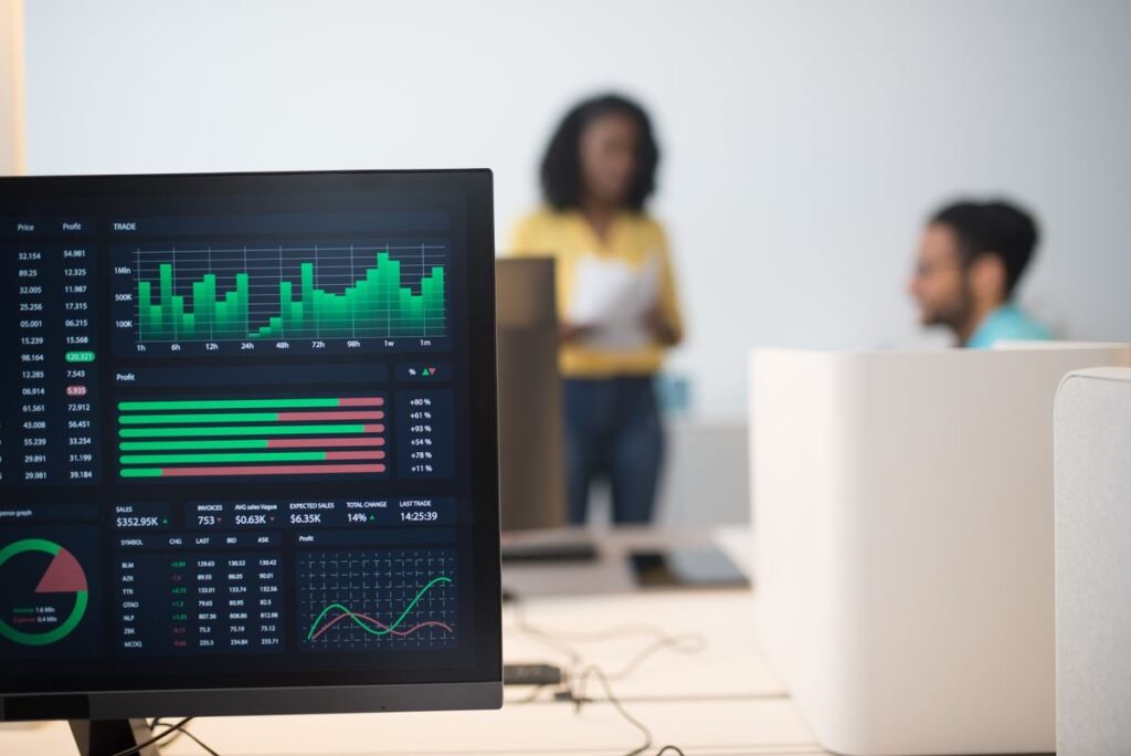 Monitor showing a dashboard of green bar charts in an office