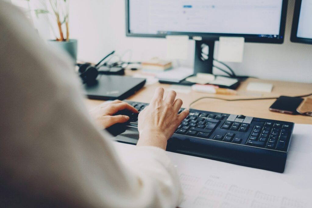 Person typing at a desk with a monitor
