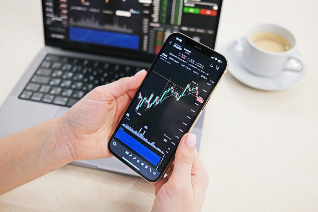 Trader reading financial news on a phone at a desk before the open, checking what caused an overnight gap