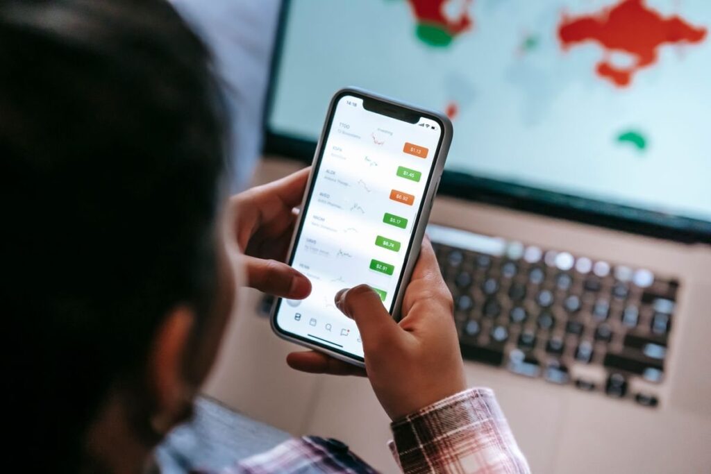 Hand holding a phone with a trading app