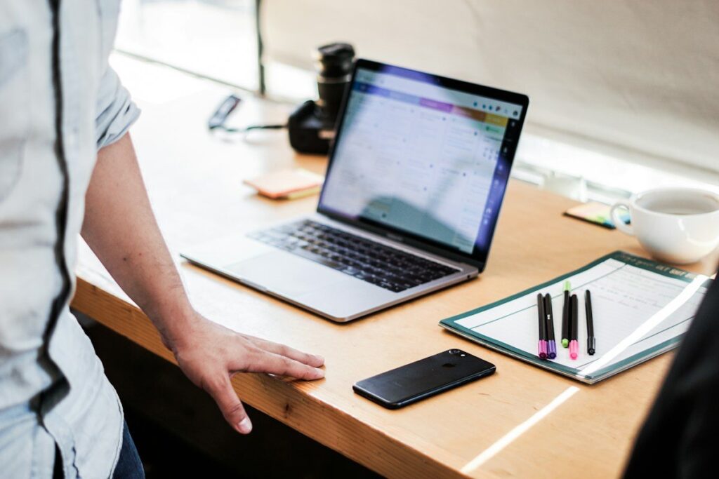 Person standing at a desk with an open laptop, deciding to skip a weak gold zone rather than force a trade