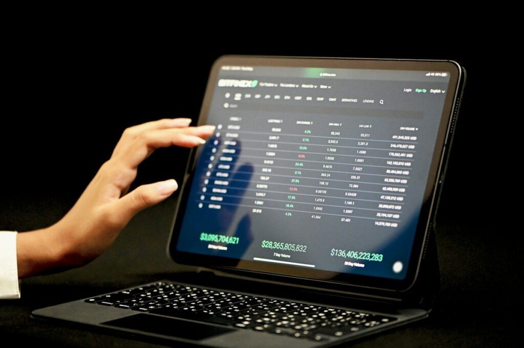 Hand touching a tablet showing a crypto platform