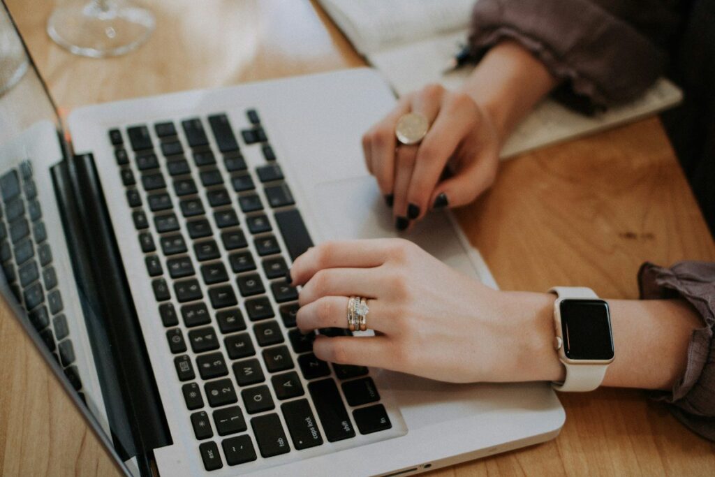 Hands typing on a laptop to start a trading journal