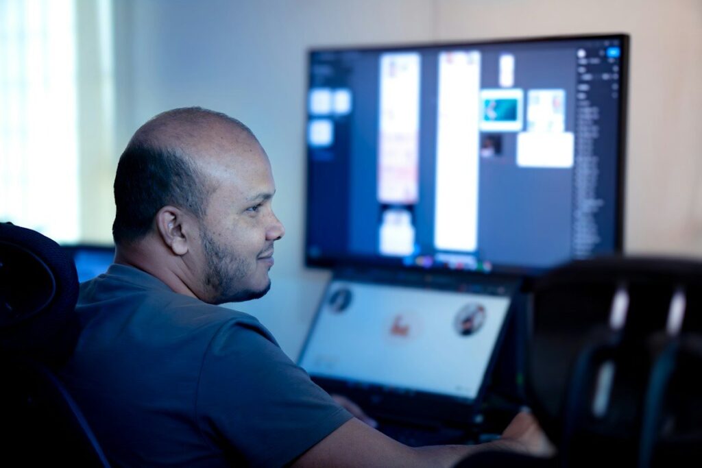 Trader smiling at a computer monitor at his desk