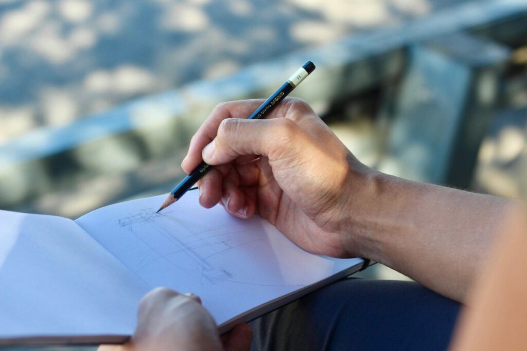 Hand drawing a horizontal retest zone in a notebook while planning a breakout and retest entry
