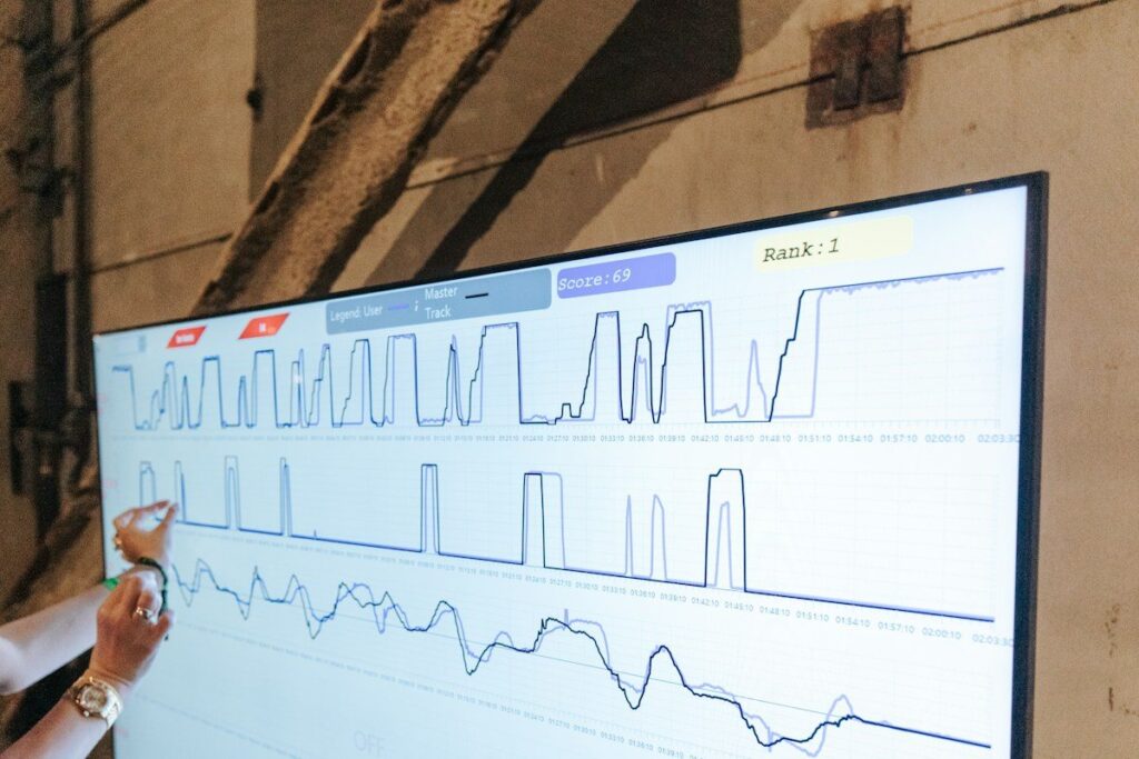 Person pointing at line graphs on a large screen