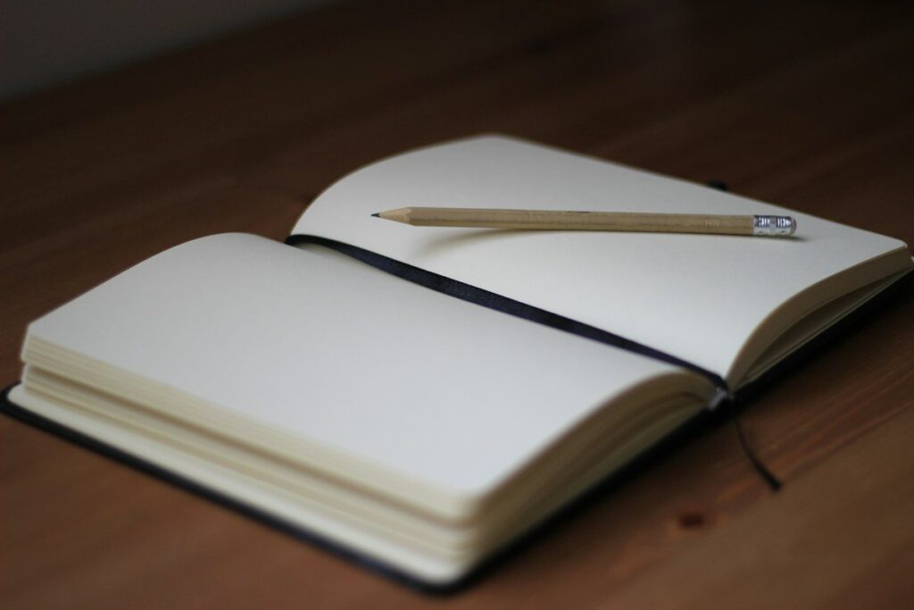 Pencil on an open blank notebook, used to log each move of a trailing stop behind swing lows