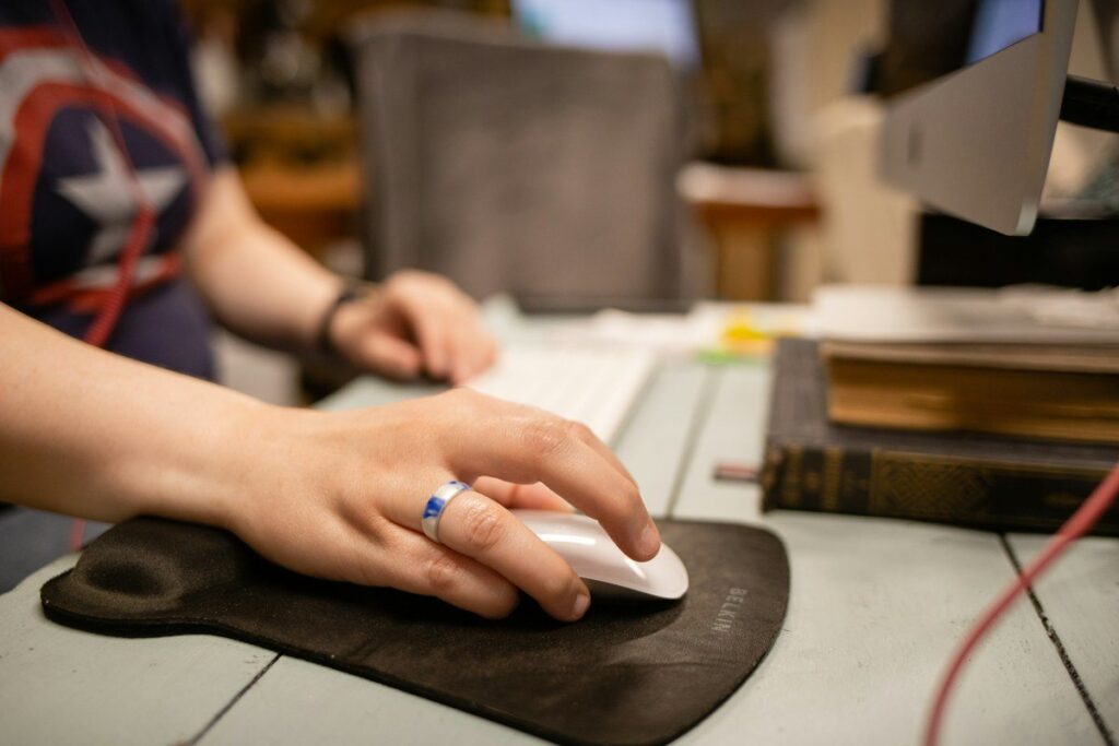 Hand gripping a computer mouse tightly, ready to re-enter a market straight after a stop-out