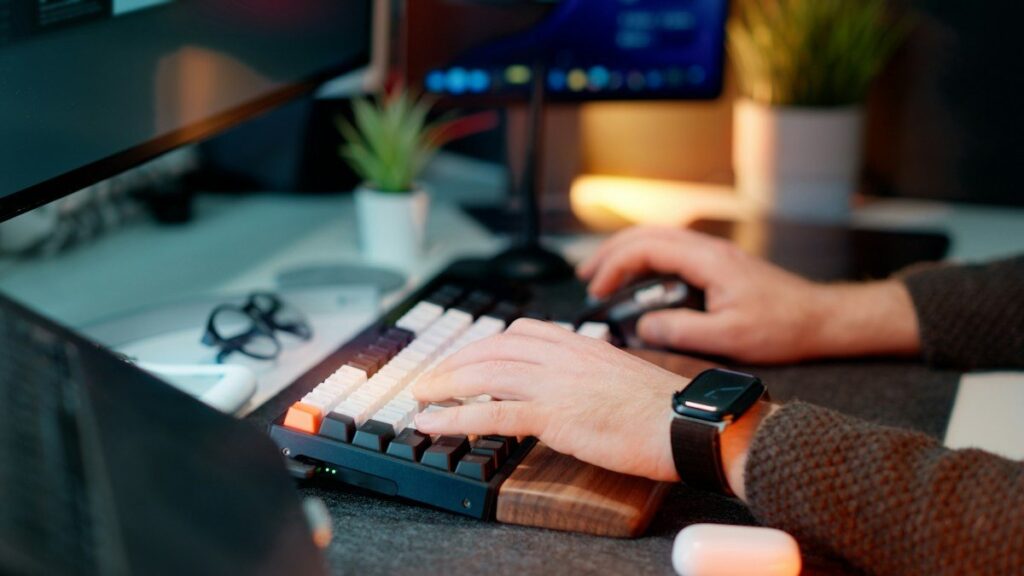 Hands on a keyboard and mouse at a desk