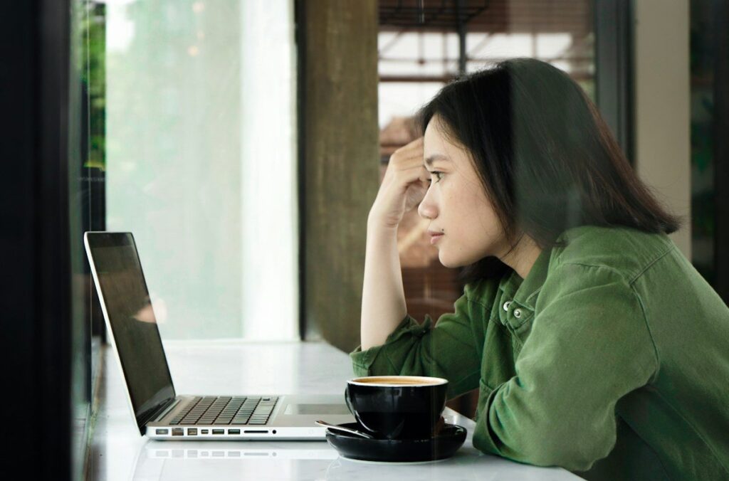 Worried person looking at a laptop, checking an account balance during a trading drawdown