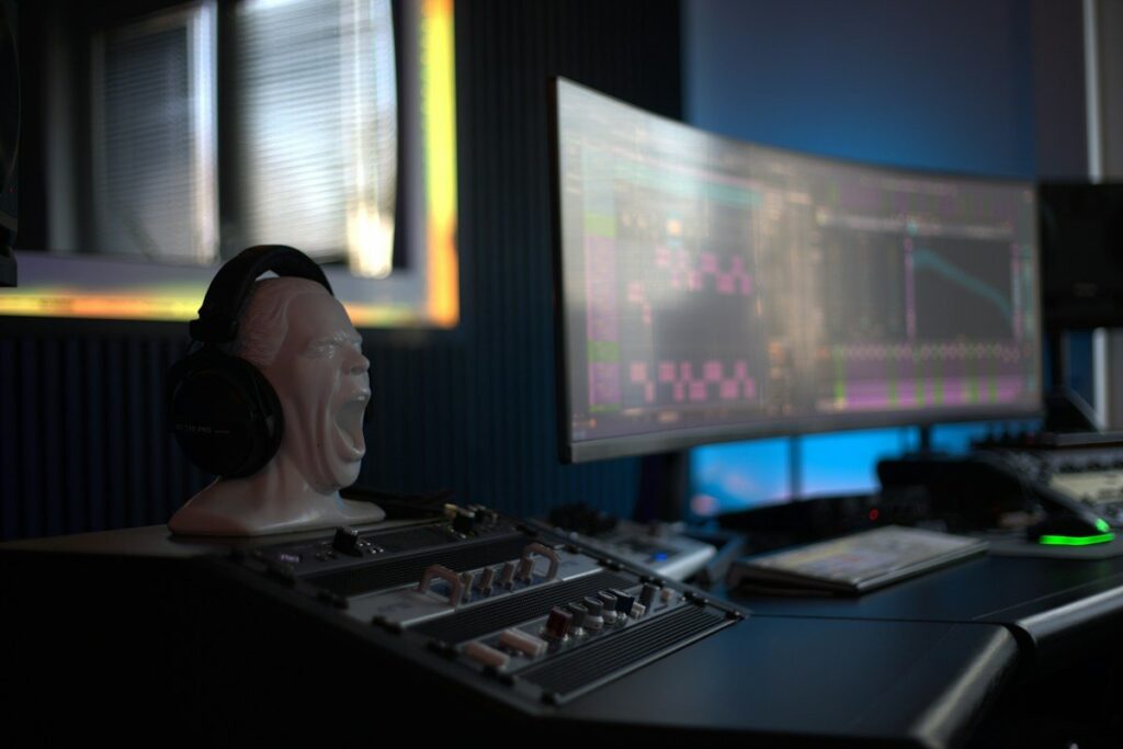 Curved monitor with charts on a desk beside headphones