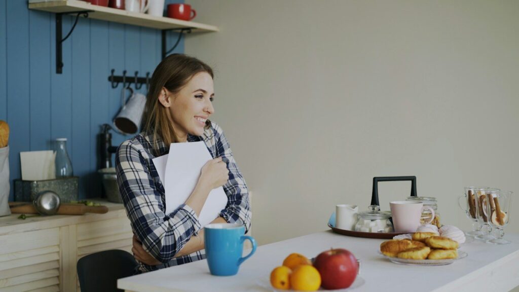 Woman holding a notebook at a kitchen table, reviewing past double top and bottom setups