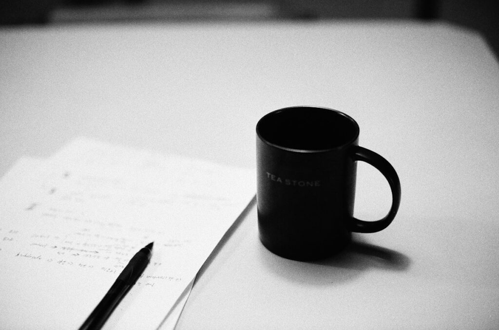 Printed results sheet beside a coffee cup, checked for common mistakes in a trading system