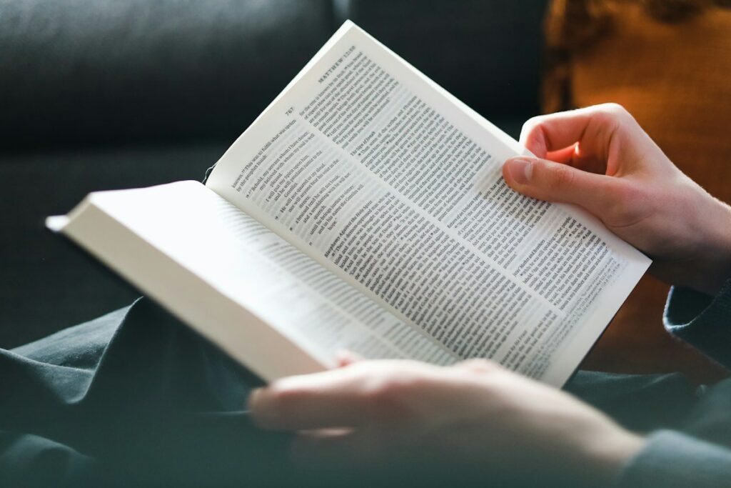 Hands holding an open book at the weekend, reviewing past retest trades for repeated mistakes