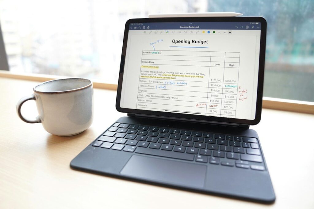 Tablet showing a spreadsheet beside a cup on a table