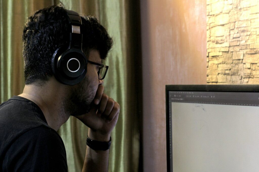 Man with headphones looking at a monitor