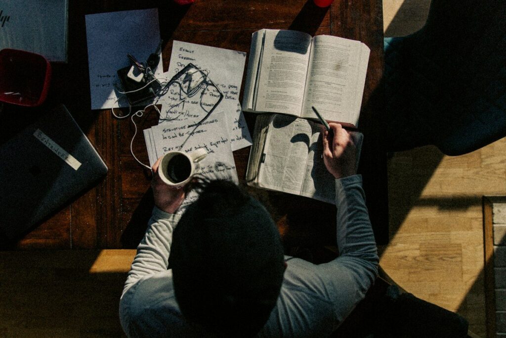 Man reading his notes at a table, reviewing a week of trades from his trading journal