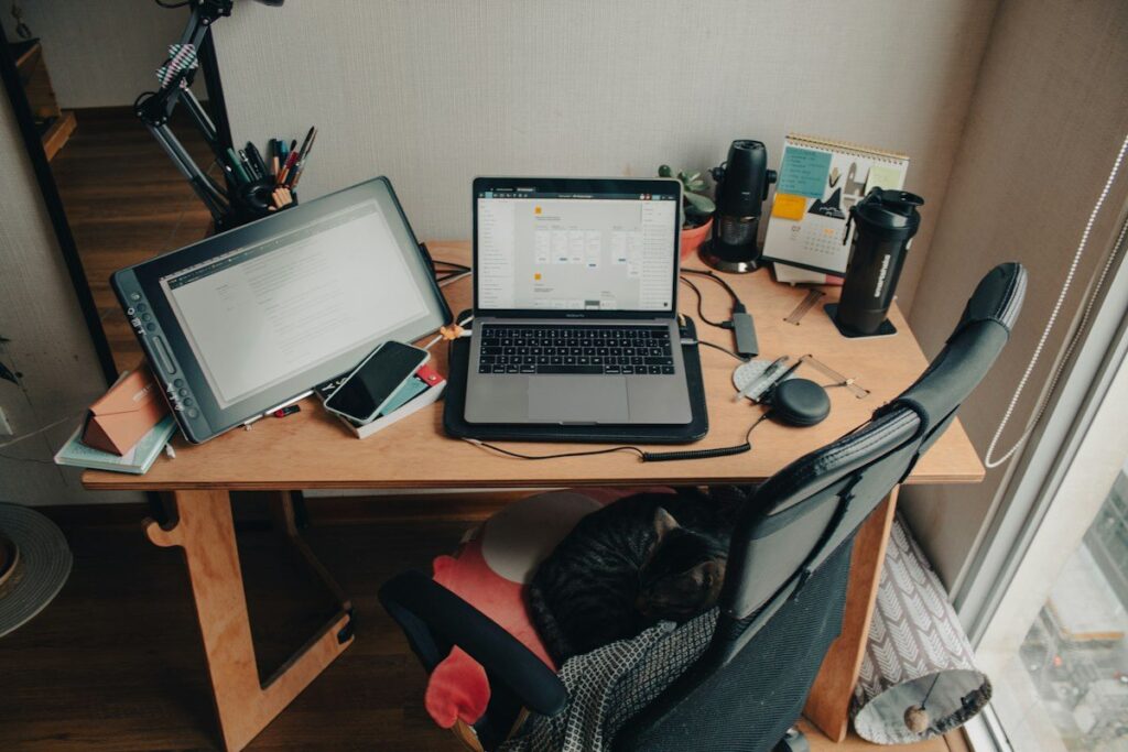 Desk with a laptop and a drawing tablet in a small room