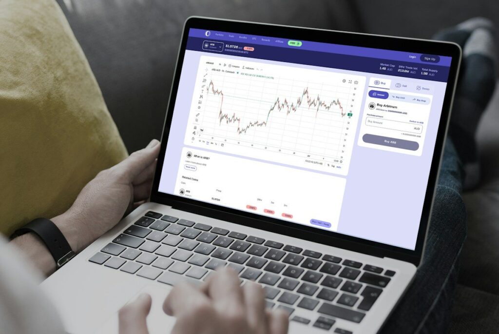 Hands on a laptop showing a trading app chart