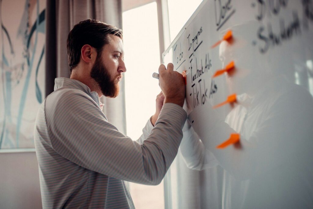 Person drawing lines on a whiteboard while building one trading method step by step