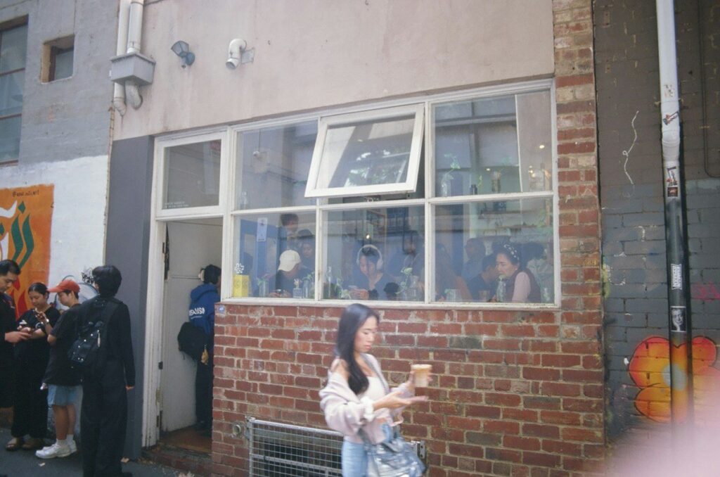Person holding a coffee on a city street, waiting for the first reaction to a data release to settle