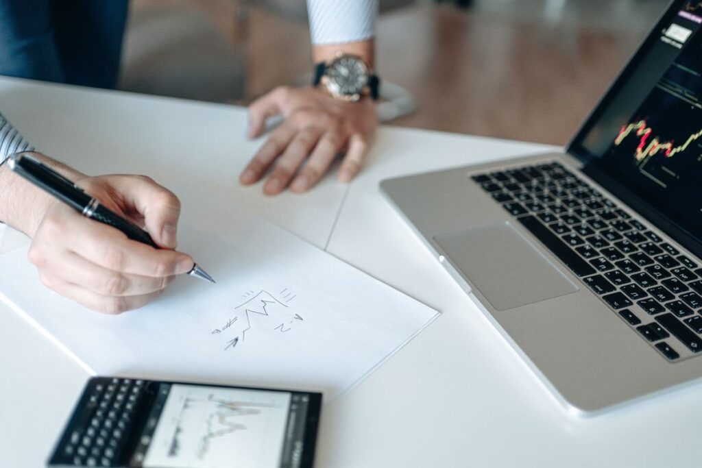 Trader writing a trading plan next to a chart