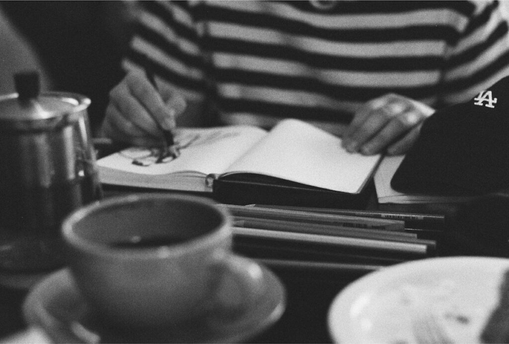 Hand writing a trade plan in a notebook, planning a trade from a tested demand zone
