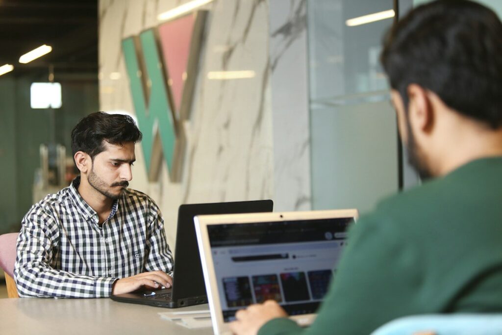 Two men working on laptops in an office