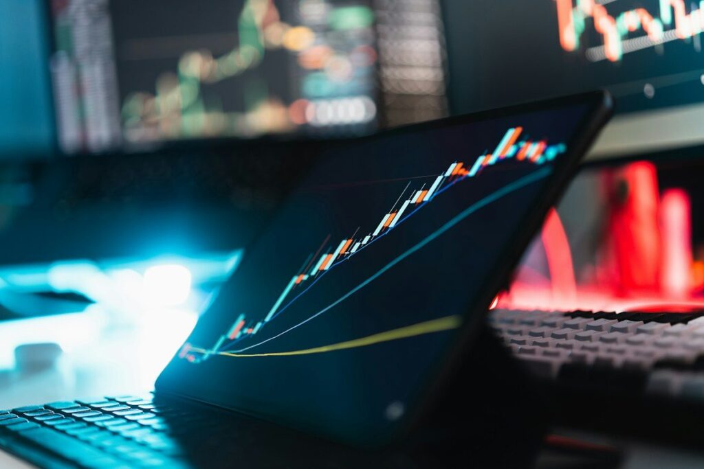 Tablet showing a rising line chart in front of glowing screens