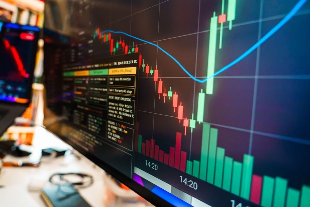 Monitor showing a candlestick chart and volume bars