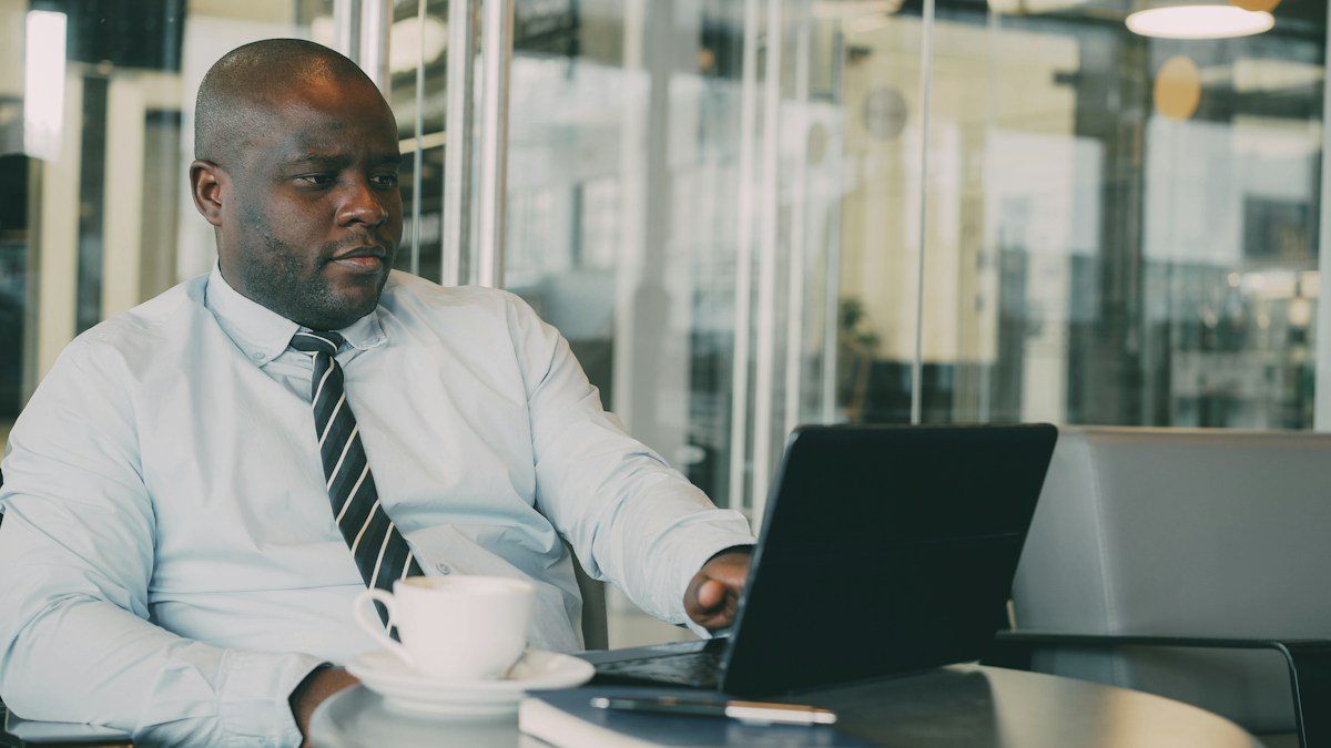 Calm trader at a desk with a notebook, reflecting on the psychological hurdles of trading