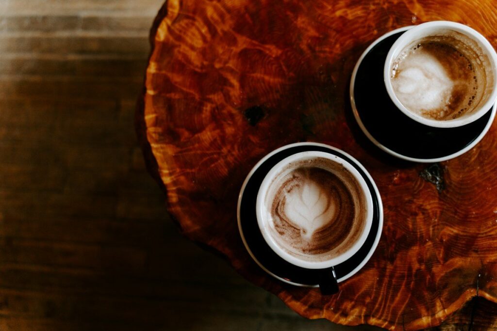 Two cups of coffee side by side on a wooden table, like two trading products that look alike but differ in detail