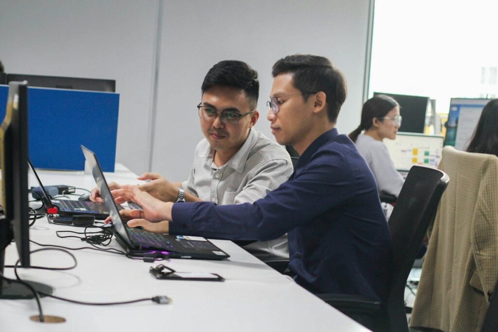 Two colleagues working at a laptop in an office
