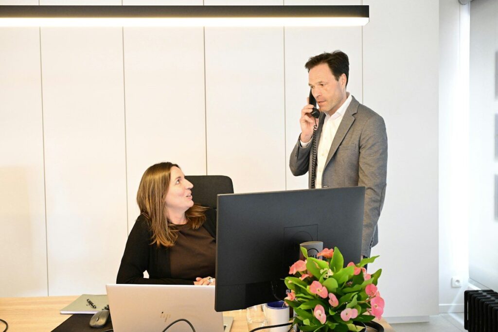 Two colleagues talking at a desk, weighing up price action against indicator readings