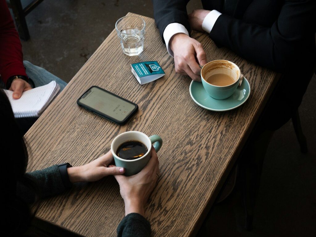 Two traders talking over coffee about trading mindset and the hurdles they face