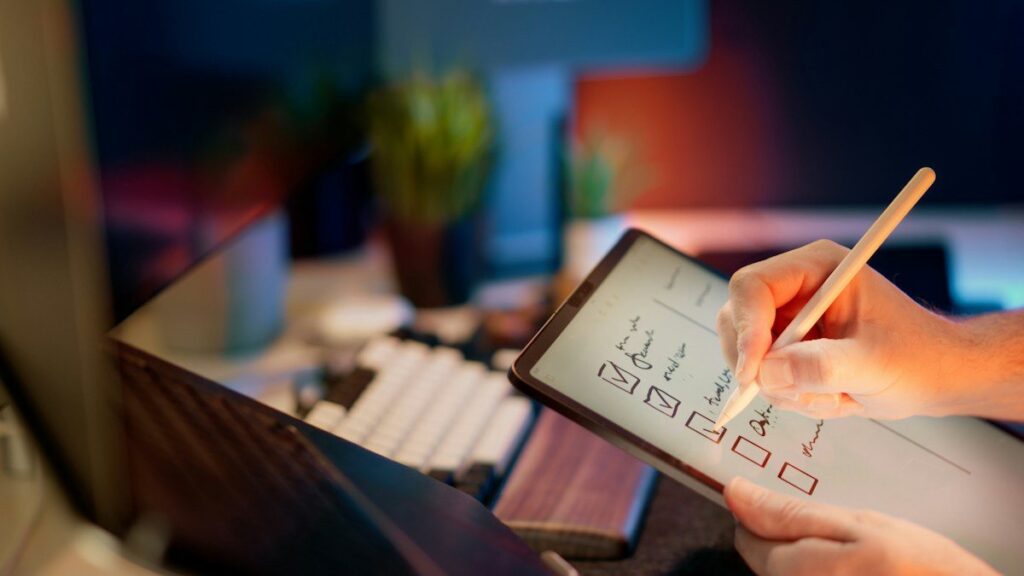 Hand ticking a checklist on a tablet with a stylus