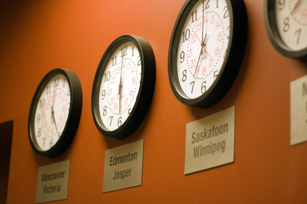 Row of clocks showing different time zones on an orange wall