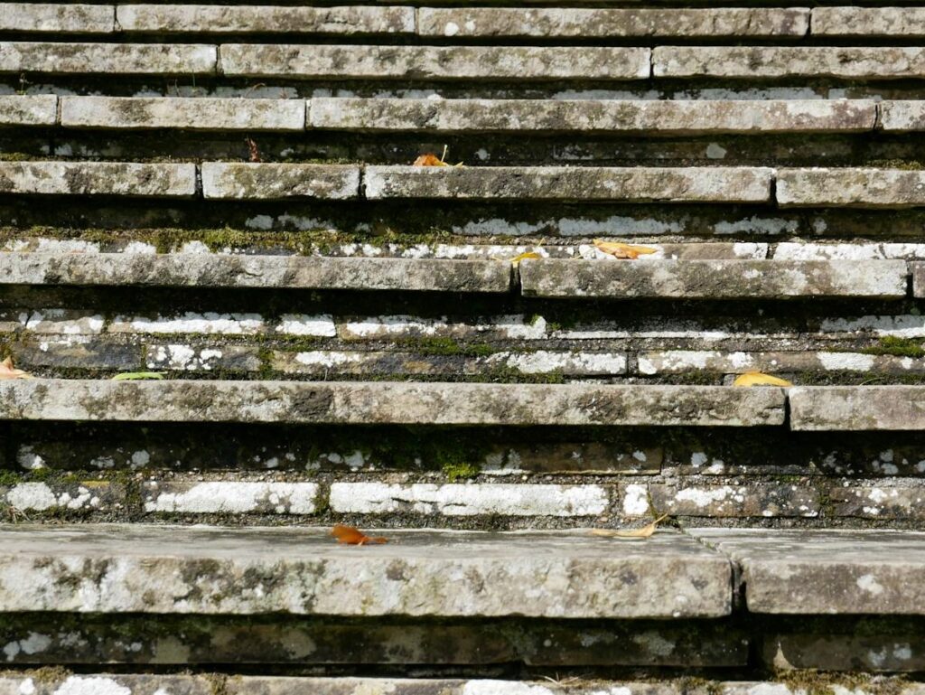 Worn grooves on an old stone staircase, showing how repeated visits can wear down a tested zone